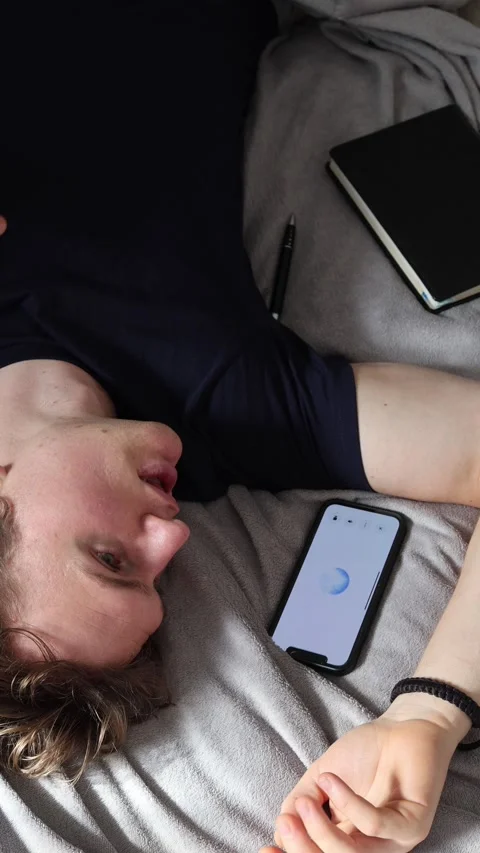 Vertical screen communication with artificial intelligence man lying on bed near Stock Footage 314979521