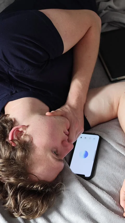 Vertical screen communication with artificial intelligence as young man lies on  Stock Footage 314979647