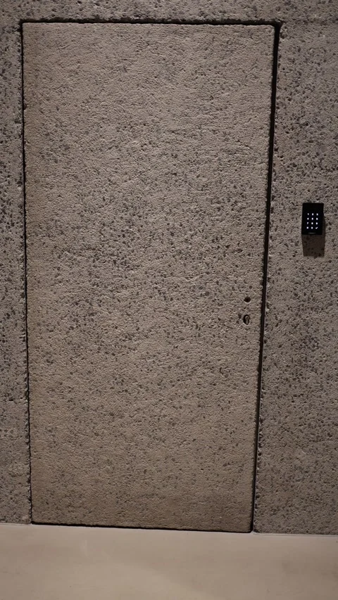 Vertical screen: A concealed door seamlessly blends into the textured concrete w Stock Footage 304459524