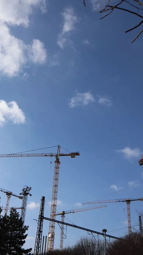 Vertical screen: A construction site with multiple tower cranes working under a  Stock Footage 303850503