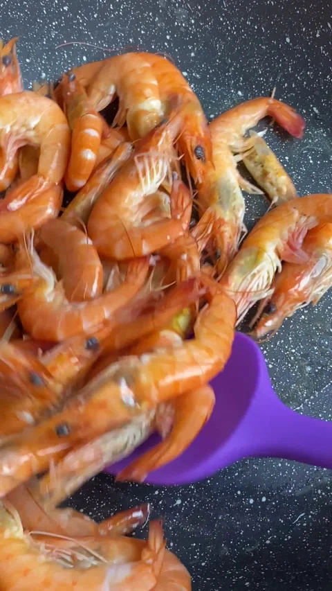 Vertical screen: cooking shrimp in a hot pan, frying seafood close-up camera Stock Footage 238699646
