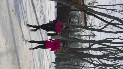 Vertical Screen: Couple jogging on snow in park Stock Footage 243425375