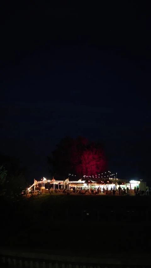 Vertical screen Cozy night bar with glowing lights and outdoor seating attracts  Stock Footage 312676572