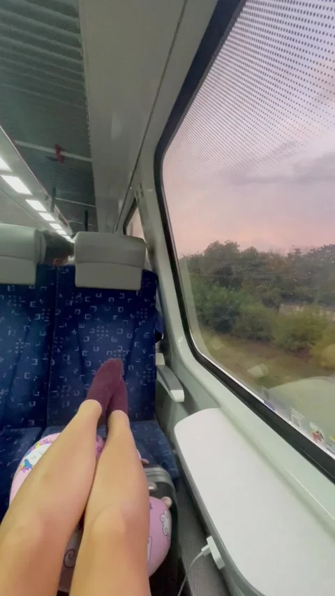 Vertical screen: A cozy train ride scene with legs stretched on the seat, a sere Stock Footage 296532696