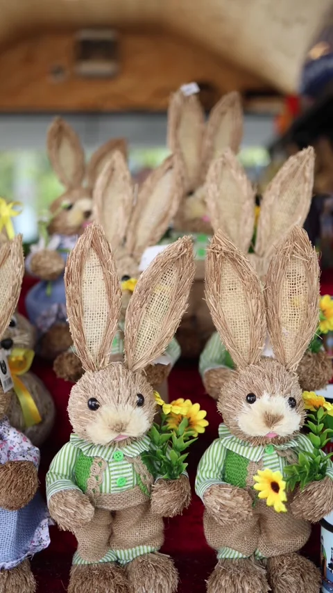 Vertical screen cute straw Easter bunnies with big ears and flowers in tiny hand Stock Footage 306677895