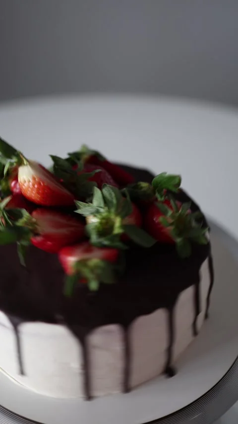 Vertical screen: A delicious close-up of a creamy cake topped with fresh strawbe Stock Footage 302794383
