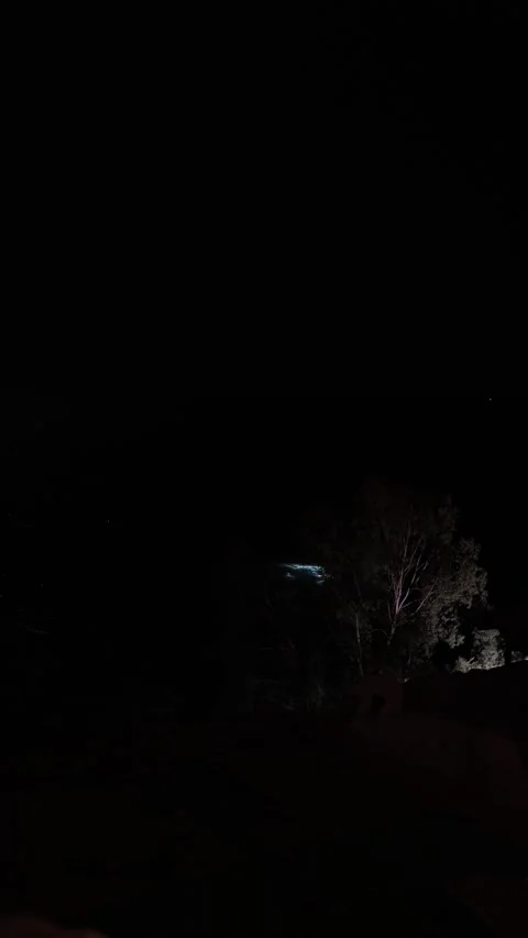 Vertical screen distant view of nighttime scene with divers searching for eviden Stock Footage 310533846