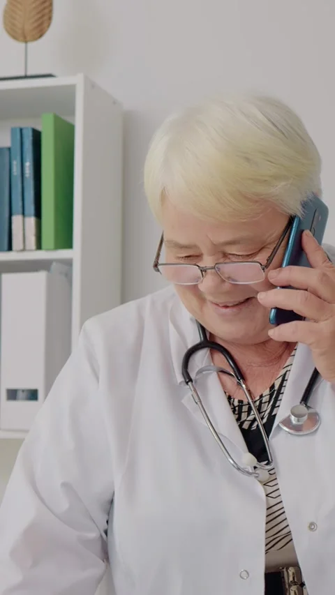 Vertical Screen Doctor giving instructions to her patients though phone. Stock Footage 299992802