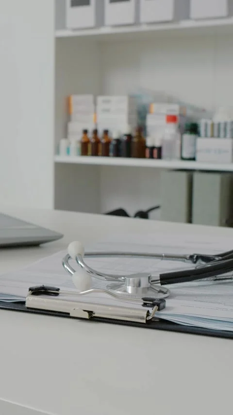 Vertical Screen Doctors desk with medicat tools and laptop. Stock Footage 299991123