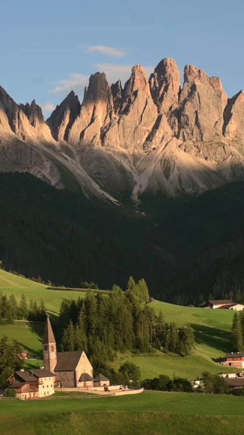 Vertical screen dolomites mountain peaks above alpine church and village italy Stockbeeldmateriaal 318721883