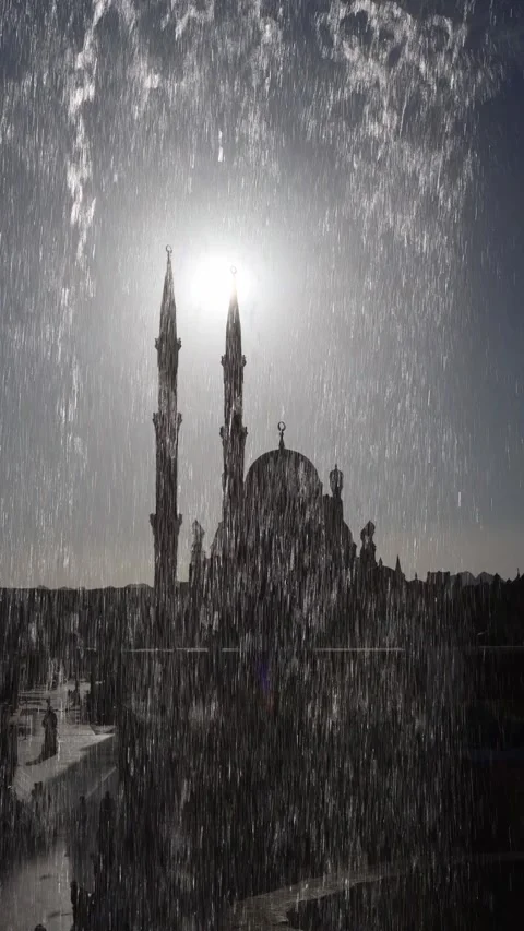 Vertical screen dramatic silhouette of mosque minarets and dome behind cascading Stock Footage 310020432