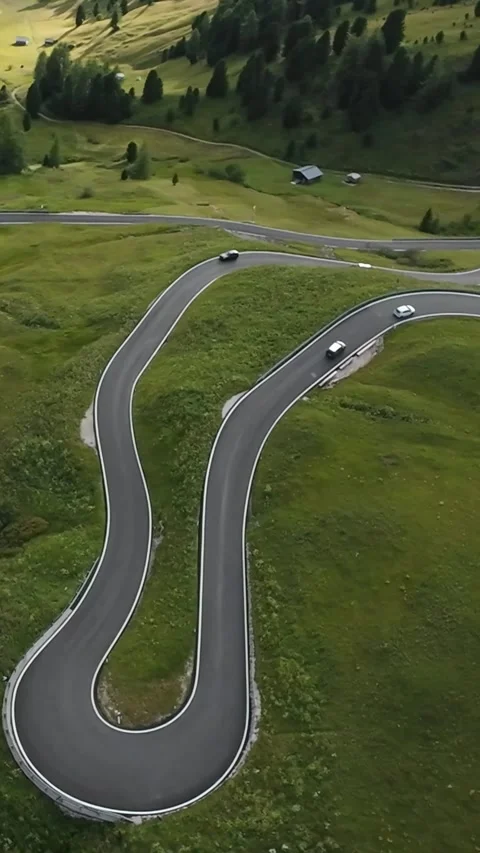 Vertical screen Drone shot dramatic hairpin mountain pass with multiple cars Stock Footage 323980451