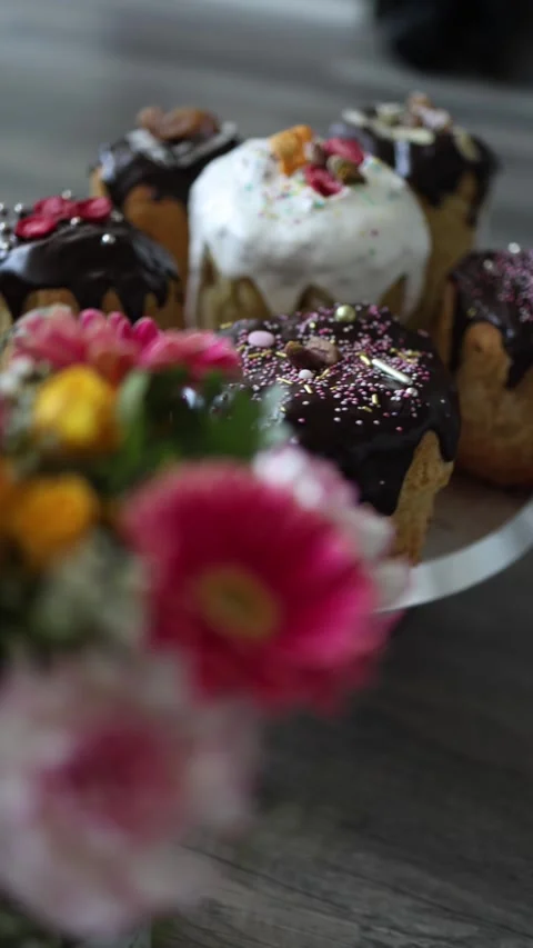 Vertical screen Easter cakes with chocolate glaze and white icing stand behind b Stock Footage 307142698