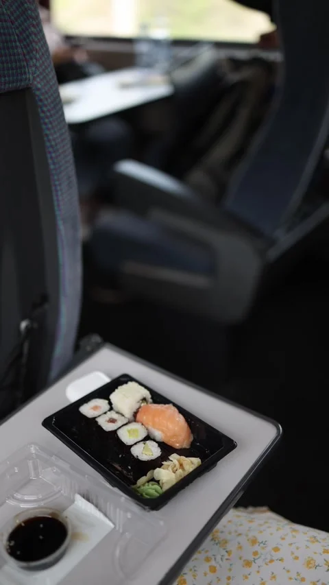 Vertical screen eating fresh sushi on board during a comfortable trip, modern tr Stock Footage 307698934