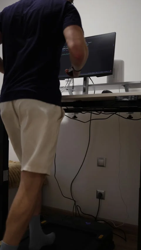 Vertical screen energetic programmer runs on treadmill while coding and working  Stock-Footage 346881588