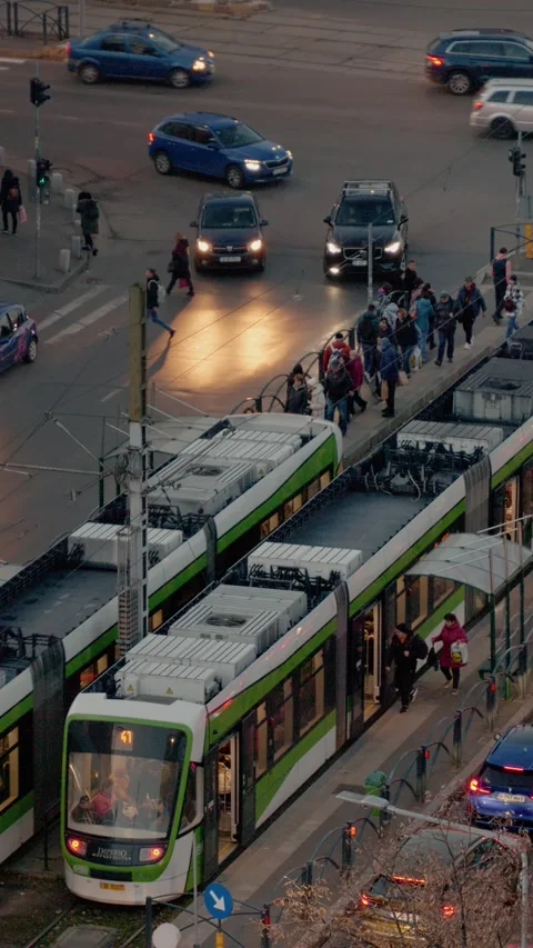 Vertical Screen Evening traffic at a busy intersection with cars and a tram 스톡 동영상 303505183