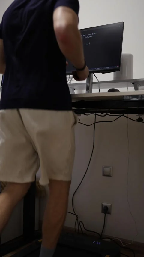Vertical screen faceless programmer runs on treadmill while working with code on Stock-Footage 346881638