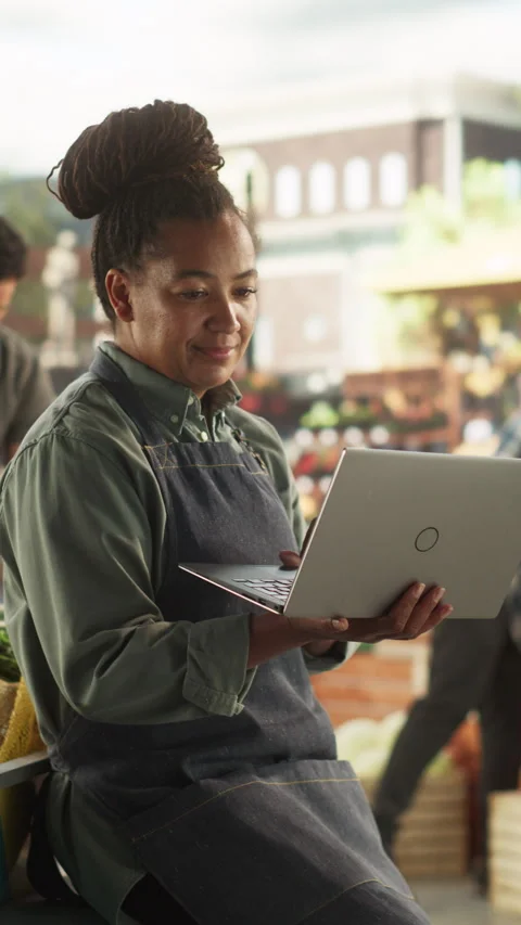 Vertical Screen Female Farmer Using Laptop Computer at a Market Stock Footage 251720061
