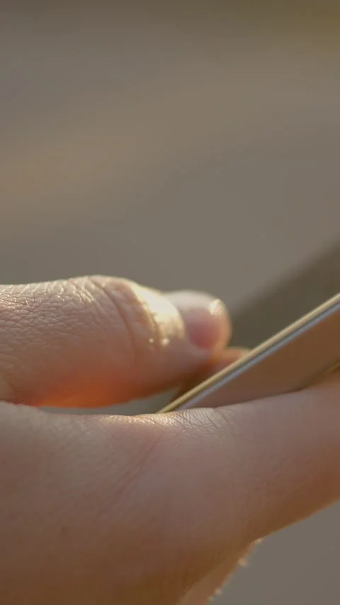Vertical Screen Female hand using smartphone in a park Stock Footage 303564597