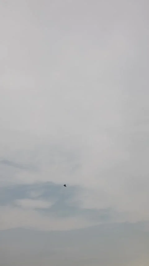 Vertical screen fighter jet shoots upward with sharp angle leaving faint smoke t Stock Footage 311150139