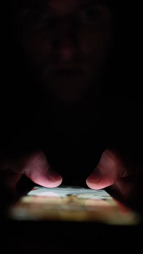 Vertical screen Fingers press on glowing phone screen in the dark displaying soc Video stock 313842775
