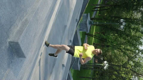 Vertical Screen: Fit man running up on staircase while jogging Stock Footage 247435409
