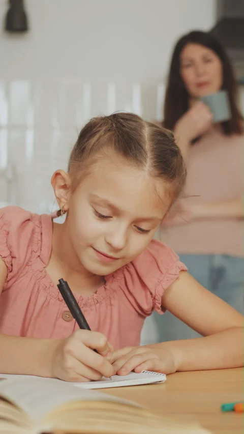 Vertical screen: Focused Girl Doing Homework in Kitchen Stock Footage 279154040