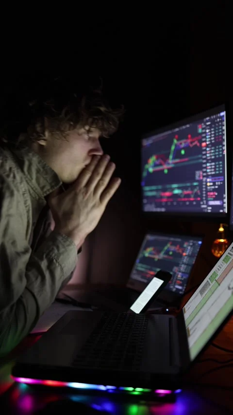 Vertical screen: A focused individual sits before multiple monitors displaying f Stock Footage 297110214