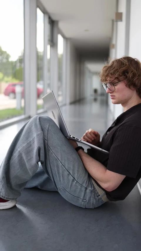 Vertical screen freelancer works on a laptop while sitting on the office floor s Stock Footage 337851560