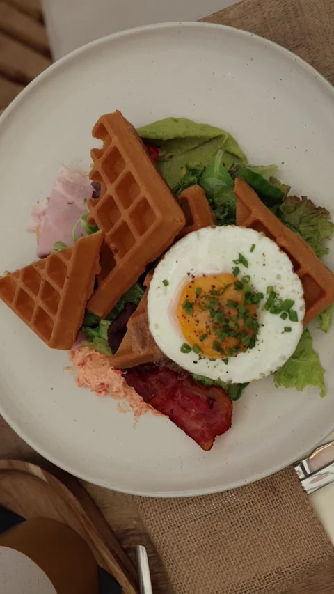 Vertical screen fresh brunch plate with golden waffles fried egg Video stock 320827133