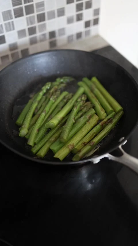 Vertical screen Fresh green asparagus cooking in pan on stovetop  Stock Footage 333031160