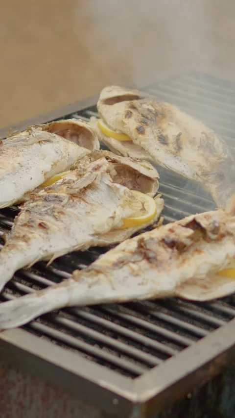 Vertical Screen Fresh sea bream grilling with lemon over hot charcoal Stock Footage 303570106