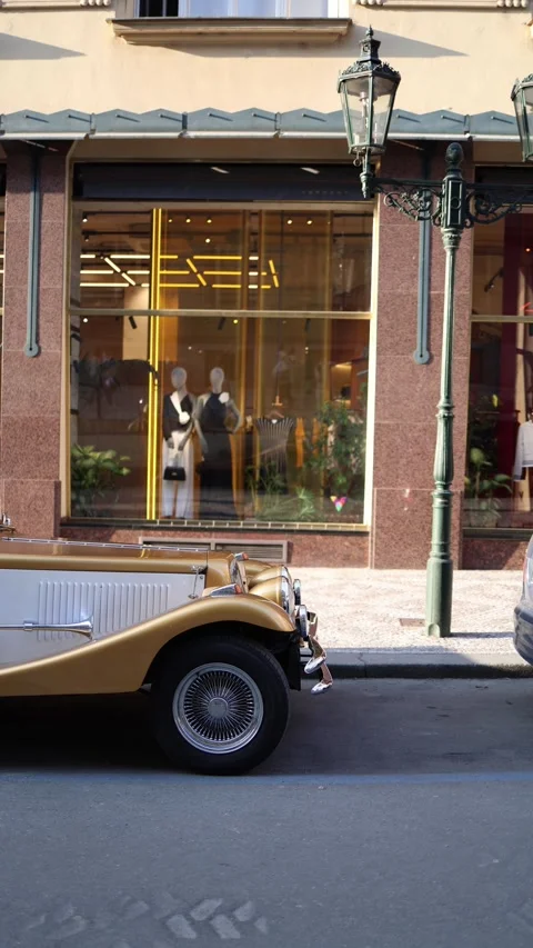 Vertical screen: Front side of a vintage gold and white car parked in front of a Stock Footage 305295309