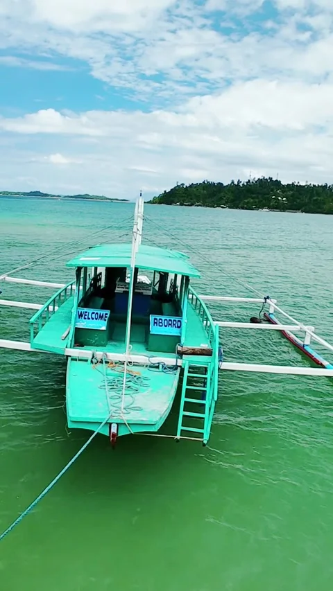 Vertical screen front view of traditional banca boat tied near tropical coast in Видео 319671381