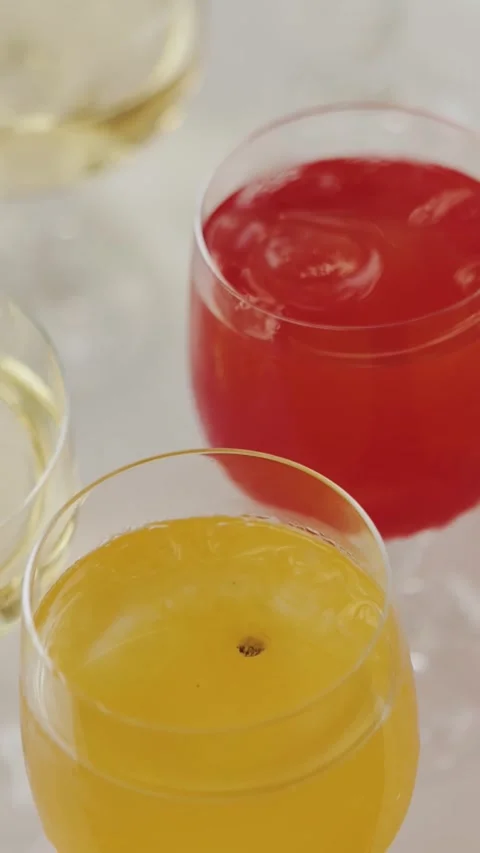 Vertical screen: Glasses of red and orange juice on a table, presented at a Stock Footage 307753273