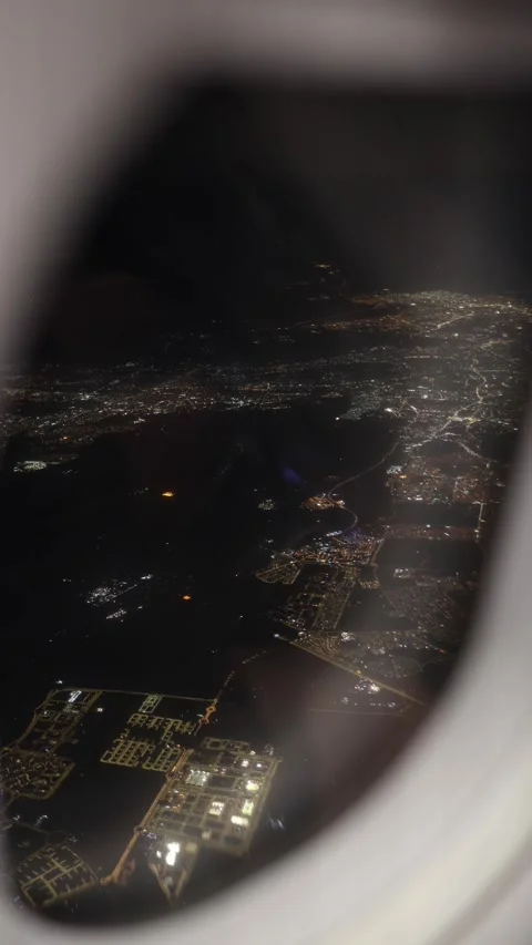 Vertical screen glowing cityscape seen through airplane window at night endless  Stock Footage 310467325