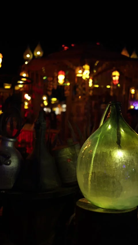 Vertical screen glowing market at night filled with antique vessels hanging lant Stock Footage 310533929