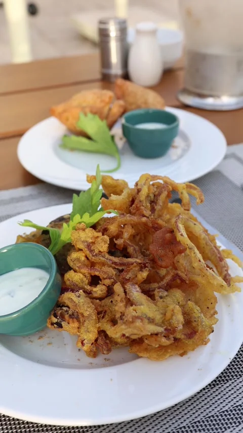 Vertical screen Golden crispy onion fritters served with creamy dipping sauce on Stock Footage 310056490