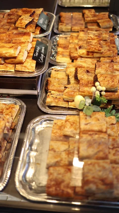 Vertical screen golden slices of cottage cheese pastry stacked on silver trays w Stock Footage 306677872