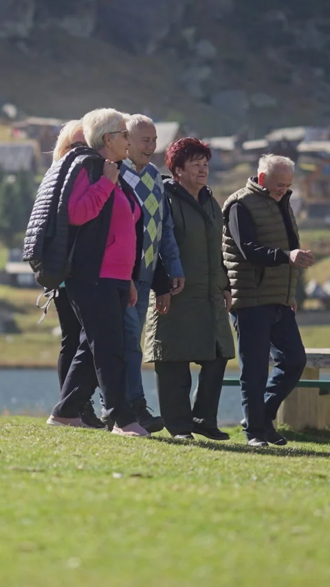 Vertical Screen: Group of Happy Elderly Caucasian People Enjoying Walk by a Lake Stock Footage 282528811