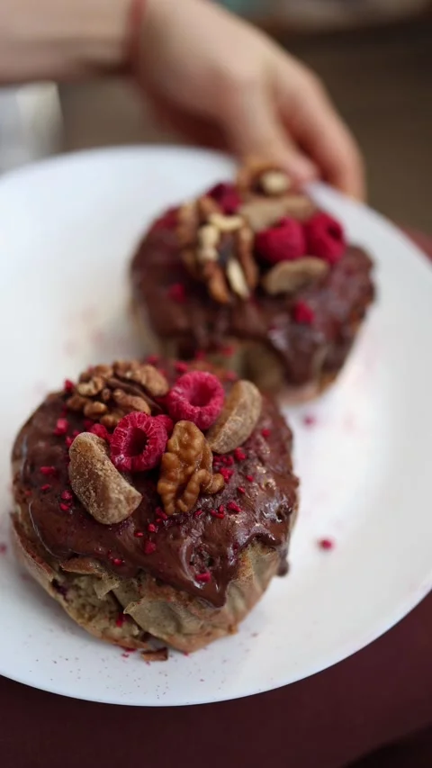 Vertical screen: Hand holding a plate with Easter pastries topped with chocolate Stock Footage 305295282