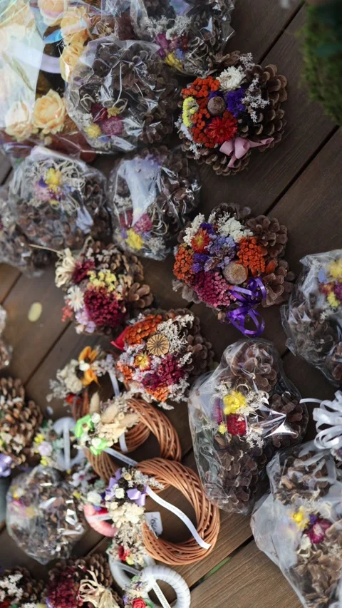 Vertical screen Handmade wreaths made of pinecones and dried colorful flowers la Stock Footage 319832421