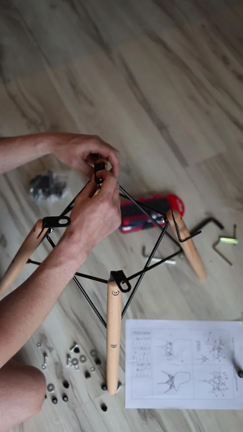 Vertical screen hands tightening bolts into wooden frame using hex key surrounde Stock Footage 310009744