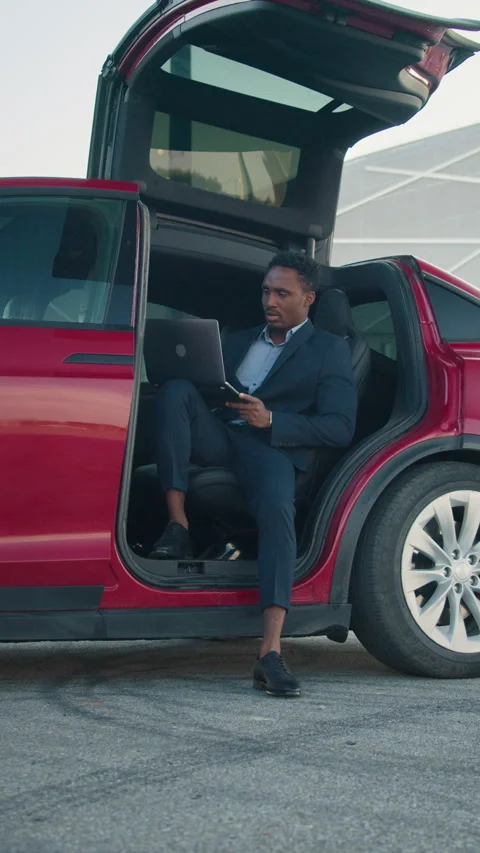 Vertical Screen: Handsome male sitting in side auto with opened door and looking Stock Footage 274264548