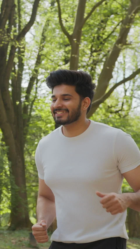 Vertical Screen: Happy muscular man dressed in sport clothes jogging during Stock Footage 274222973