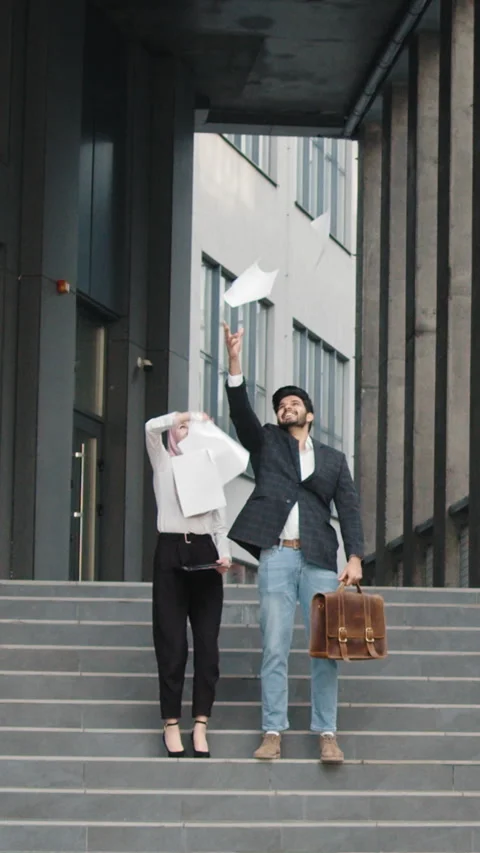 Vertical Screen: Happy muslim man and woman, Managers joyfully toss up papers Stock Footage 272837775