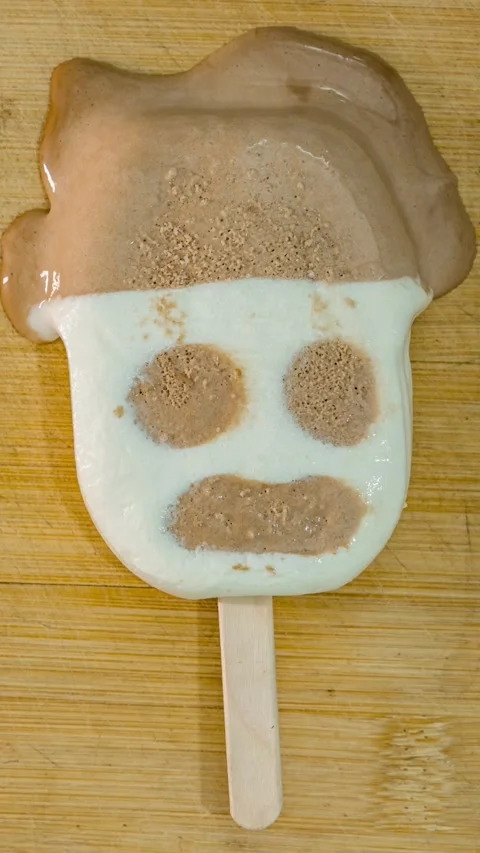 Vertical screen, human face shaped ice cream melting gradually in warm air. Stock Footage 333542720