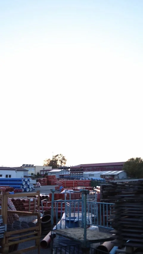 Vertical screen industrial warehouse yard with stacks of metal and plastic pipes Stock Footage 319832784