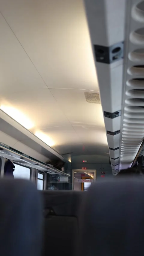 Vertical screen: Interior of a train carriage with soft lighting, showing seats  Stock Footage 299299178