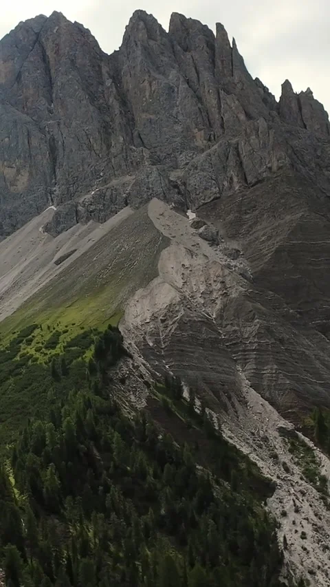 Vertical Screen Jagged Dolomites Ridge Above Forested Slope, Dramatic Overcast Stock Footage 325825226